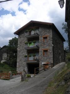 a stone building with a balcony on the side of it at Apartaments La Canal in Alins