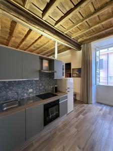 cocina con armarios blancos y suelo de madera en Lovely Rome Suite, en Roma