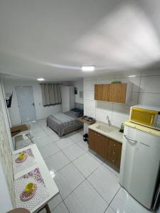 a kitchen with a refrigerator and a bed in it at Studio 107 in Sao Paulo