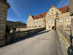 a large building with a bridge in front of it at FeWo Pelkmann Apartment 1 - Die Grüne Oase - Garten & Terrasse in Weikersheim