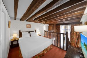 a bedroom with a bed and a balcony at Hotel de la Bretonnerie in Paris