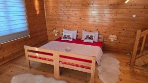 a bedroom with a bed in a log cabin at etno brvnara sa bazenom in Železnička Stanica Karlovački Vinogradi