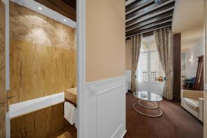 a room with a hallway with a table and a room at Hotel de la Bretonnerie in Paris +65 photos