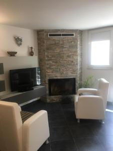 a living room with white chairs and a fireplace at Casa Francis in Matera