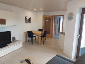 a living room with a table and chairs and a kitchen at Ferienwohnung Familie Aestel in Altensteig