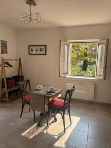 a dining room with a table and chairs and a window at L'appart Thé - Cocon de charme avec terrasse à Paradou, au cœur des Alpilles in Paradou