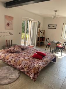 Un dormitorio con una cama grande con almohadas rojas. en L'appart Thé - Charme apaisant au coeur des Alpilles, en Paradou