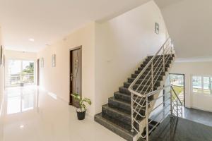 a staircase in a home with white walls and a stair case at Treebo SNS Grand Inn in Yelagiri