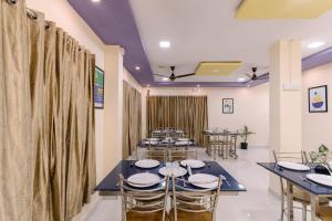 - une rangée de tables et de chaises dans une chambre avec rideaux dans l'établissement Treebo SNS Grand Inn, à Yelagiri