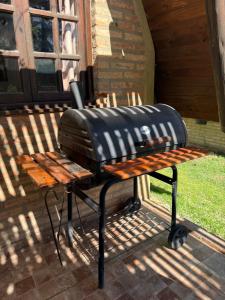 a grill sitting on top of a picnic table at Cabañas Pindahue - Alojamineto Epehuen in Villa Carlos Paz
