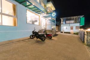 duas motocicletas estacionadas fora de um edifício à noite em Treebo SNS Grand Inn em Yelagiri mais 39 fotografias