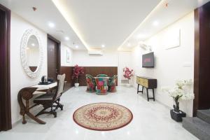 a lobby with a table and chairs and a mirror at Palm Residences and Suites in Jaipur