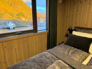 a bedroom with a bed in front of a window at Superior Cabin Ballstad Lofoten in Ballstad