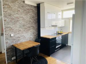 cocina con mesa de madera y pared de ladrillo en Kotimaailma - High-quality furnished apartment, en Seinäjoki