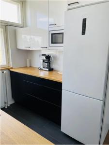 Una cocina con un refrigerador blanco y un microondas. en Kotimaailma - High-quality furnished apartment, en Seinäjoki