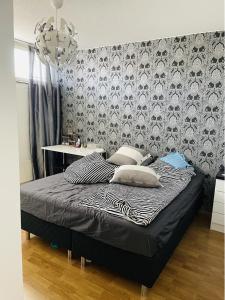 Una cama con almohadas en un dormitorio. en Kotimaailma - High-quality furnished apartment, en Seinäjoki