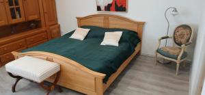 a bed with two pillows and a chair in a room at Cichy Zaułek 5A in Brodnica