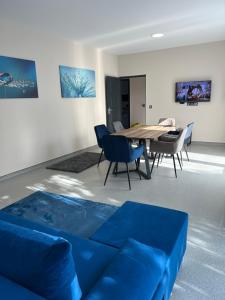 un salon avec un canapé bleu et une table dans l'établissement 4 hálószobás Pihenj Meg Vendégház, à Nyíregyháza