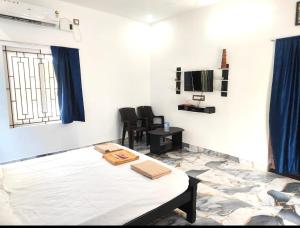 a room with a bed and a table and chairs at Coco farm homestay in Rāmeswaram