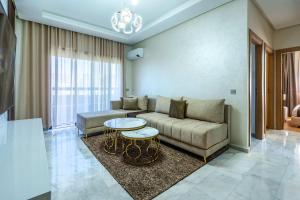 una sala de estar con un sofá y una mesa en Appartement Familial à Zenata avec Piscine, en Aïn Harrouda
