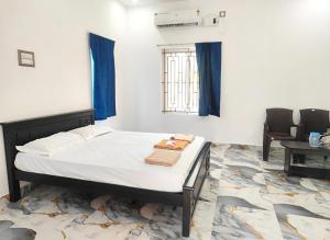 a bedroom with a bed with blue curtains and a window at Coco farm homestay in Rāmeswaram