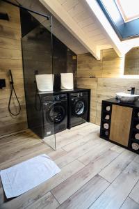 a bathroom with two washing machines and a shower at Chata Andromeda in Oravská Lesná