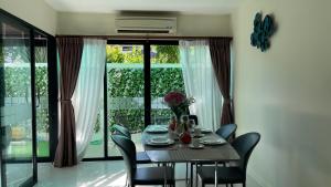 a dining room with a table and chairs and a window at Townhouse in the Wonderland in Bang Tao Beach