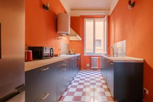 una cucina con pareti arancioni e pavimento a scacchi di Unique Bologna Penthouse with Frescoes and Charm a Bologna