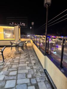 a patio with tables and chairs on a building at night at Hyatt Hotel & Aparments in Abbottabad