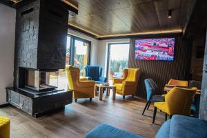 a waiting room with chairs and a fireplace at Chata Andromeda in Oravská Lesná