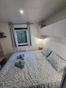 a bedroom with a large bed and a window at Houlgate - 279 - Magnifique Mobilhome 6 personnes sur Camping 5 étoiles in Houlgate +16 photos