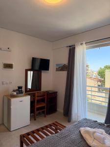 a bedroom with a bed and a television and a window at Escape at Chalandri Athens in Athens