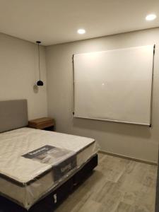 バレリア・デル・マールにあるDepto en Valeria del Marのベッド1台と大型プロジェクションスクリーンが備わる客室です。