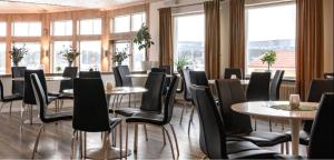 a dining room with tables and chairs and windows at Brinkeboda Wärdshus in Mörsil