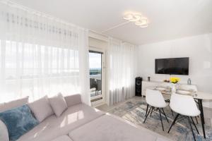 a white living room with a white couch and a table at Sommerliebe in Hansaland