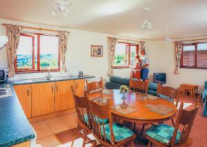un hombre y una mujer de pie en una sala de estar con una mesa en Avalon Cottages, en Llangynin