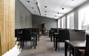 Un comedor con mesas y sillas y ventanas. en Brinkeboda Wärdshus, en Mörsil