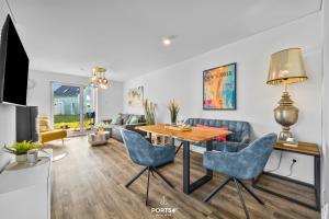 a living room with a table and blue chairs at Ferienwohnung Matrosenloft Olpenitz in Olpenitzdorf