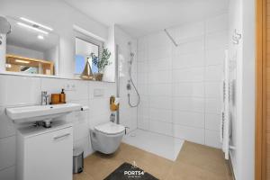 a white bathroom with a toilet and a sink at Ferienwohnung Matrosenloft Olpenitz in Olpenitzdorf +39 photos