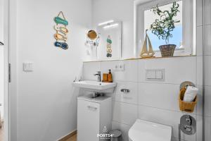 Un baño blanco con lavabo e inodoro. en Ferienwohnung Matrosenloft Olpenitz, en Olpenitzdorf 26 fotos más