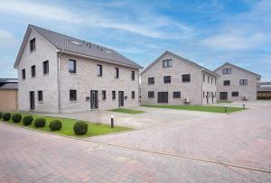 a group of three buildings on a brick road at Hemminghuus 1 Hemmingstedt in Hemmingstedt
