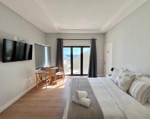 ケープタウンにあるBlouberg Village Placeのベッドルーム1室(大型ベッド1台、デスク、テーブル付)