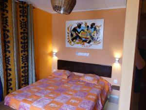 a bedroom with a bed and a picture on the wall at Villa Charlestine in Yaoundé