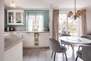 a kitchen with a table and chairs and a dining room at Haus Sofie in Utersum