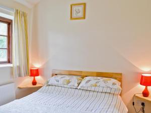 1 dormitorio con 1 cama con 2 lámparas rojas en The Old Chapel, en Burshill