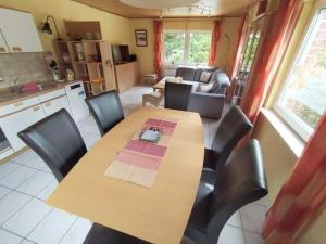 a kitchen and dining room with a wooden table and chairs at Waldwiese RE15 in Sögel +16 photos