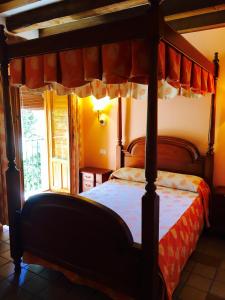 a bedroom with a canopy bed and a window at Hostal Posada La Panadera in Sepúlveda