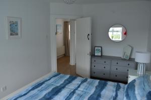 ein Schlafzimmer mit einem Bett, einer Kommode und einem Spiegel in der Unterkunft 32 Benbane Park in Portballintrae