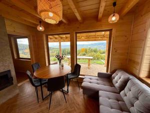 a living room with a couch and a table with chairs at Slow Mountains in Wola Piskulina