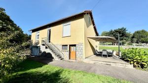 une maison avec un escalier, une table et un parasol dans l'établissement Le refuge, Wifi, Parking privé, Proche Limoges, terrasse, jardin, à Le Palais-sur-Vienne